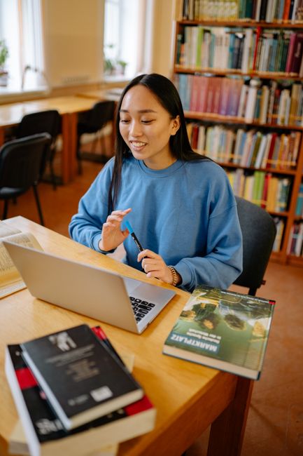Laptop mit geöffneter Online-Deutsch-Lektion und Notizbuch